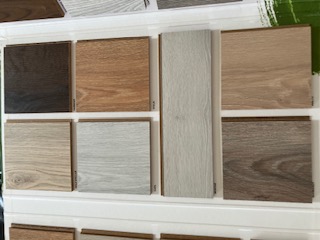 Laminate and vinyl flooring sample boards in light and dark oak tones