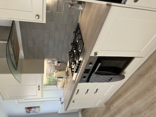 Kitchen run with grey metro tile splashback, oven and hob